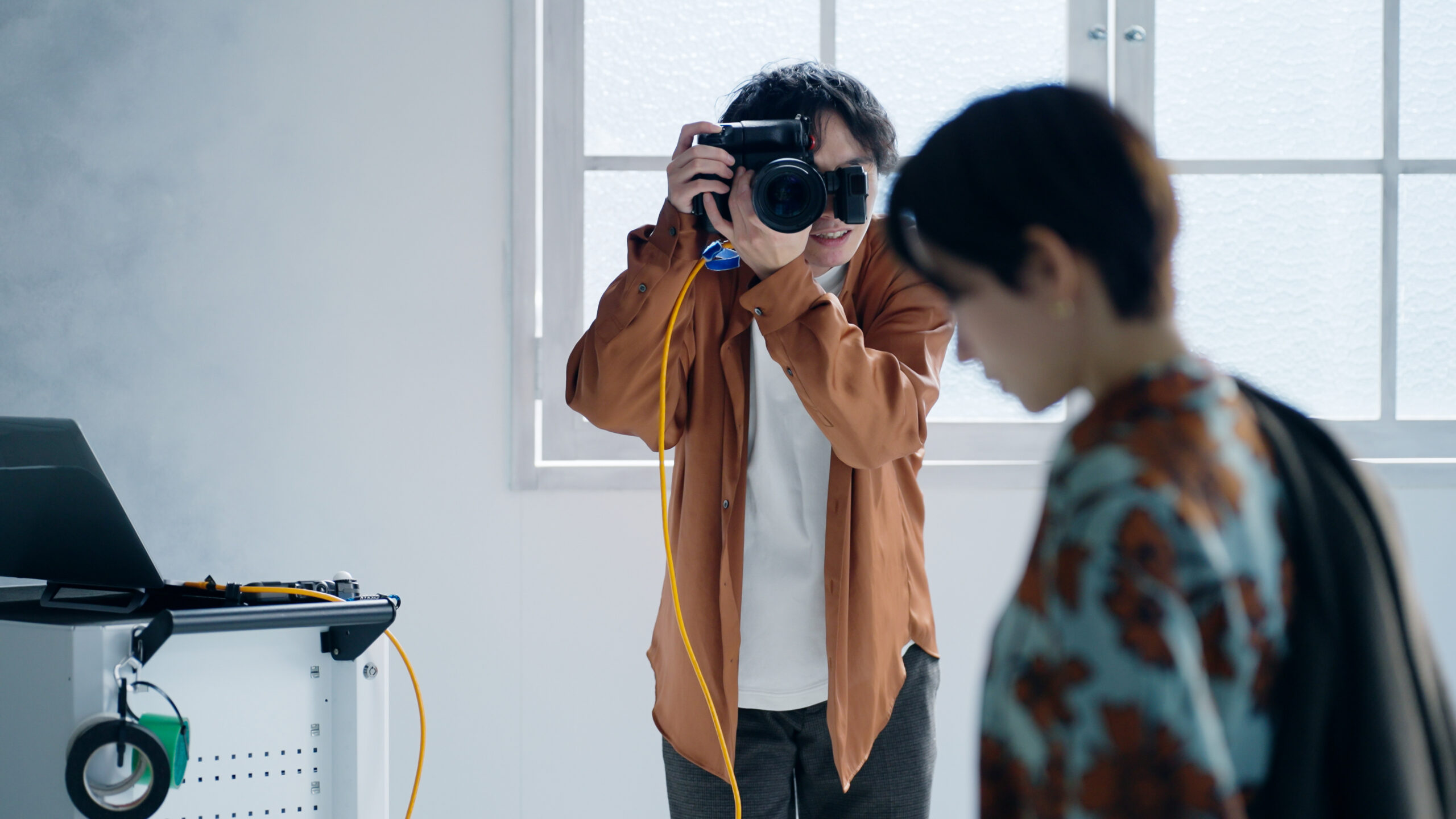 撮影する男性カメラマンと女性モデル